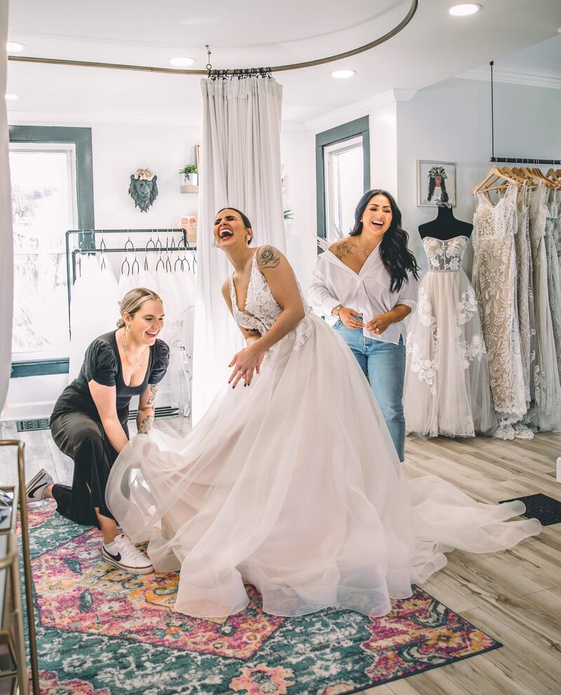 bride trying on dress and laughing