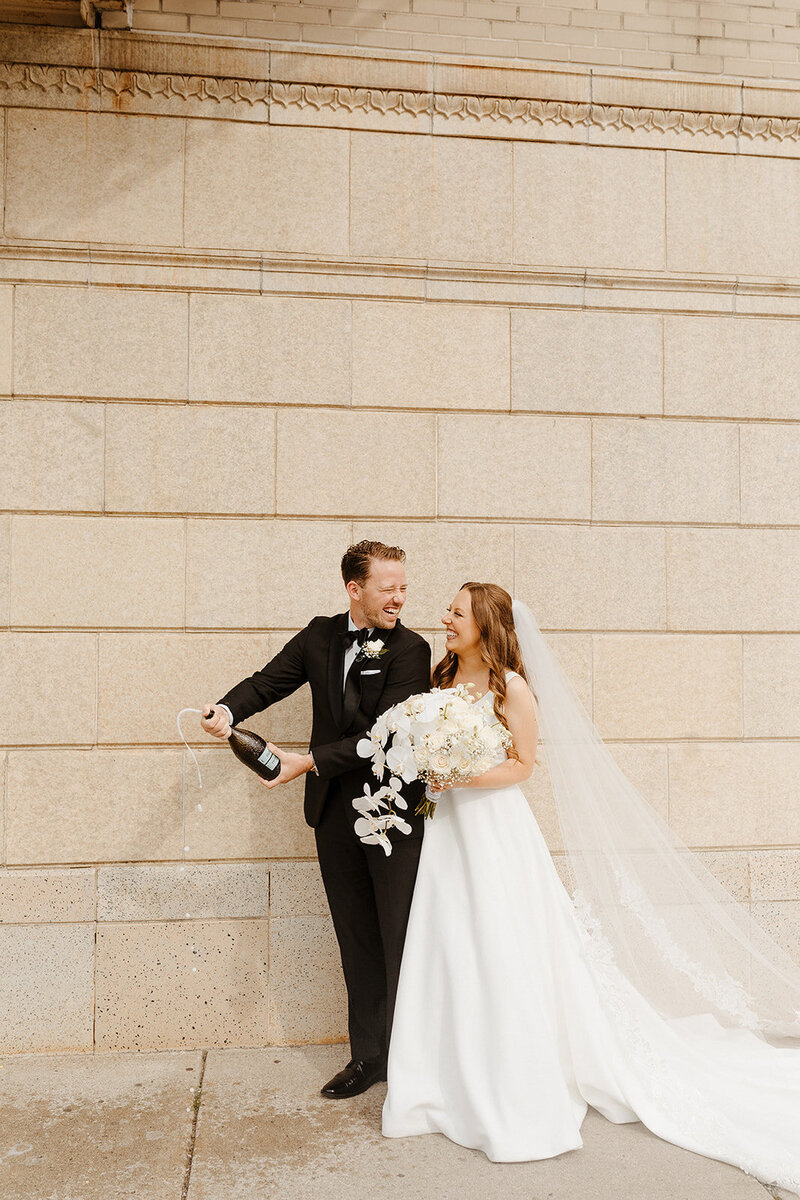 bride and groom holding hands looking at the camera