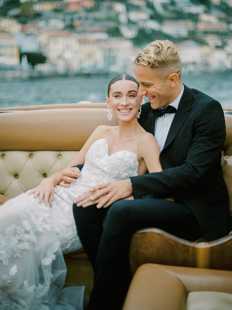 A-bride-and-groom-sitting-on-a-boat-in-lake-como