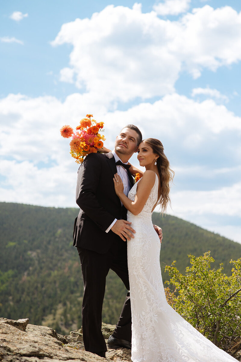 A luxury wedding photographer capturing editorial styled couples portraits at a mountain overlook viewpoint in Idaho Springs