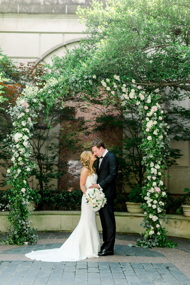 Swank Soiree Dallas Wedding Planner Katie and Austin - Bride and Groom kissing under an arbor