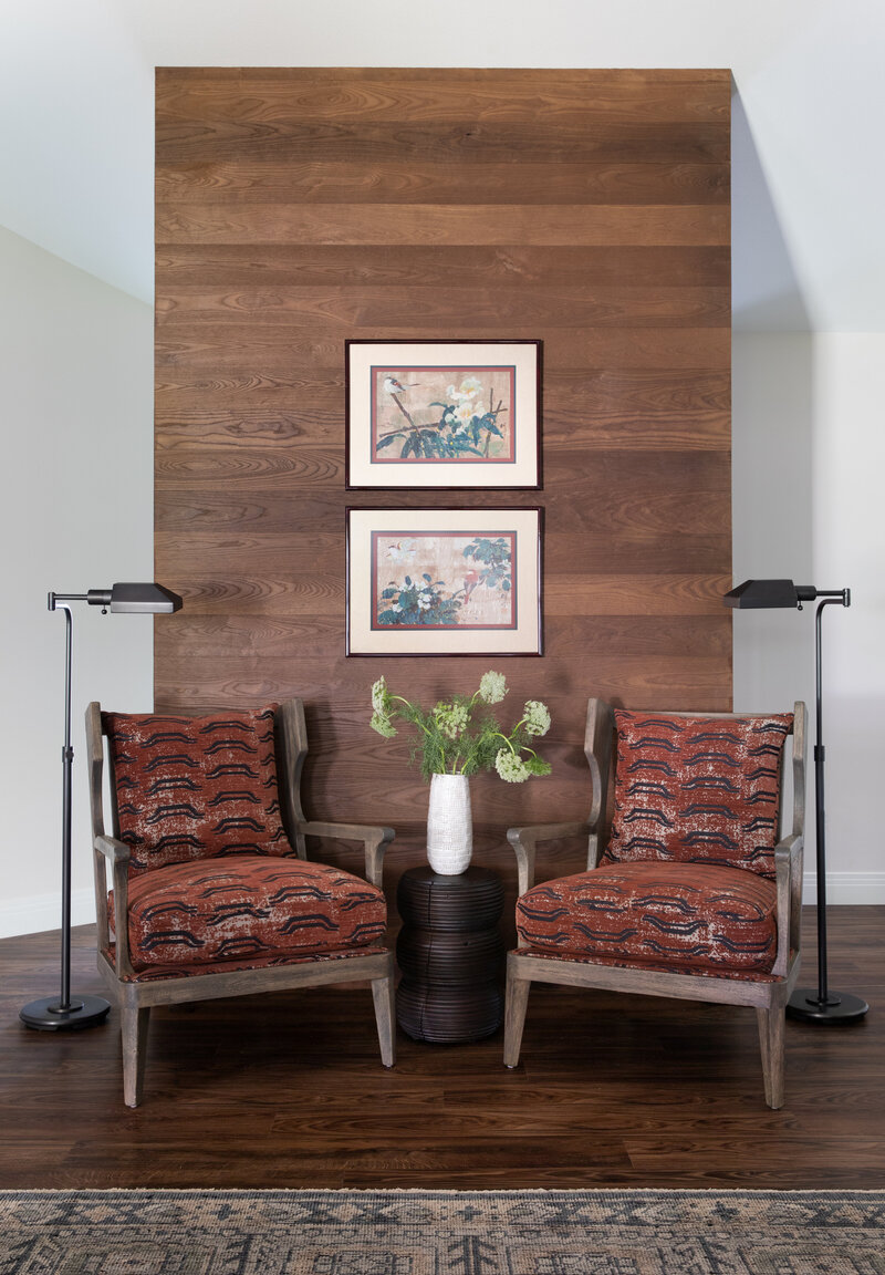 Westlake Home Interior - Entry foyer with a wooden vignette accent wall. Classic captain's chairs with red themed upholstery and earth tone rugs. Chinese waterpaint art on wall between chairs.
