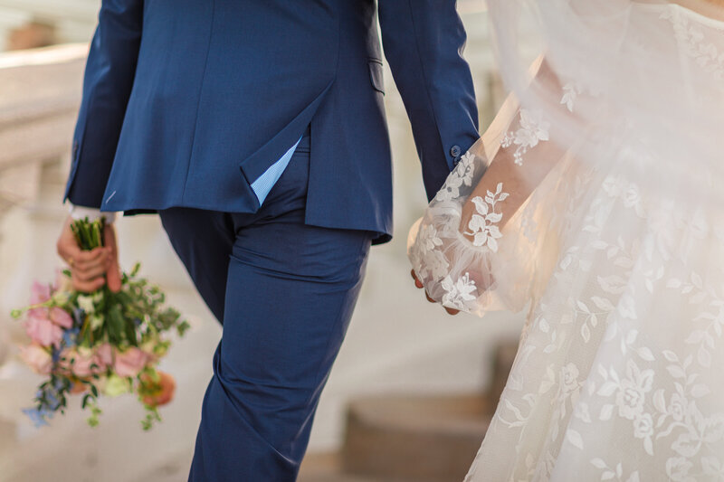 A Bride and Groom at the altar having their portrait taken, surrounded by a huge flower arrangement.