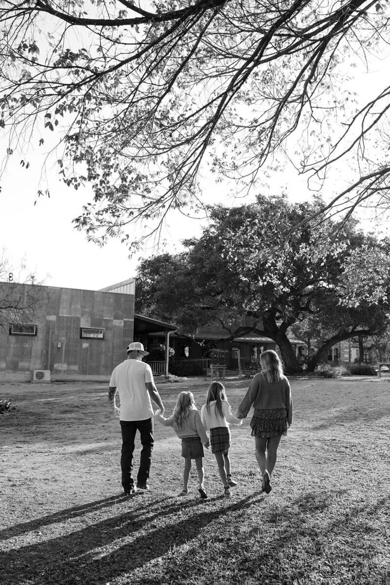 A family walking away holding hands in Gruene Texas.