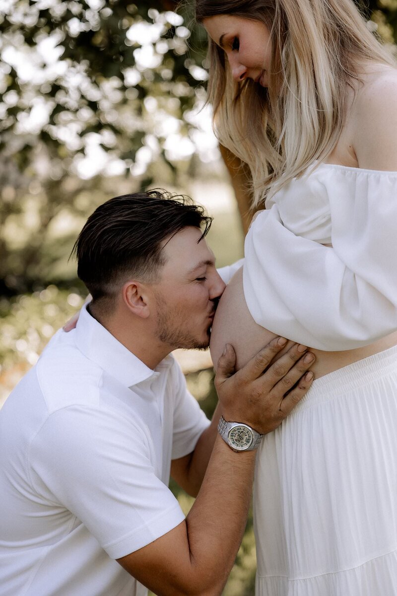 dad kissing pregnant mom's bare belly, photo taken by mary wiebe photography maternity photography in lubbock texas