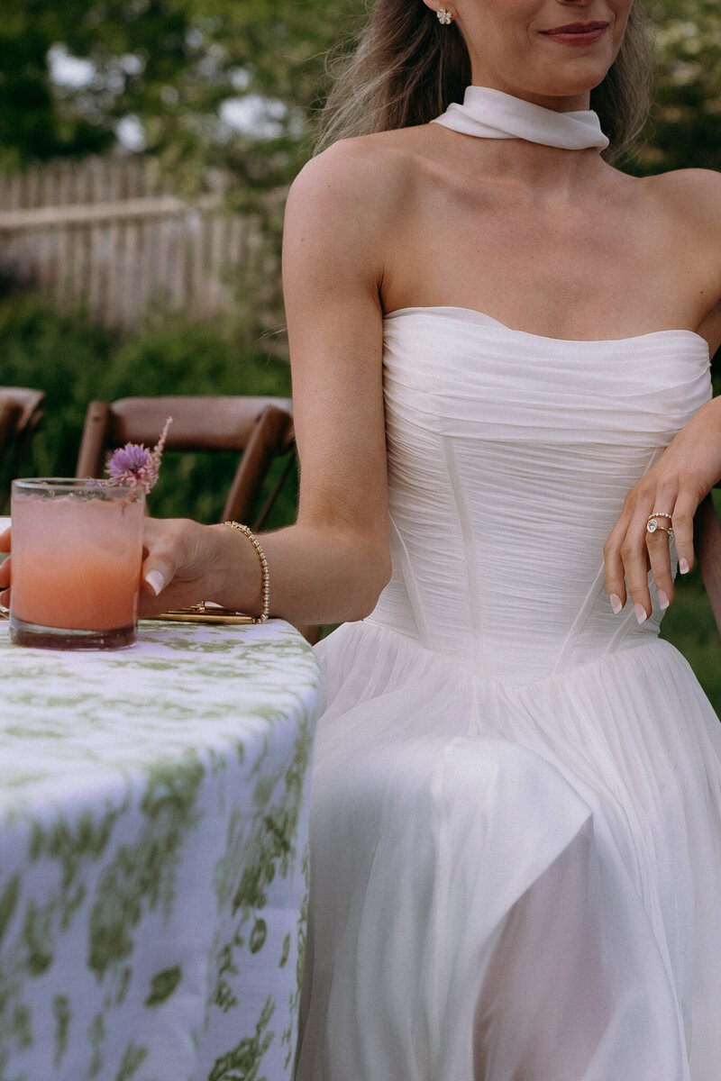 Vermont Wedding Photographer | Sincerely Liz Photography Documentary Wedding, Engagement, Elopement, Maternity and Newborn Photographer in New England | Bride holding a pink mocktail while sitting at wedding reception