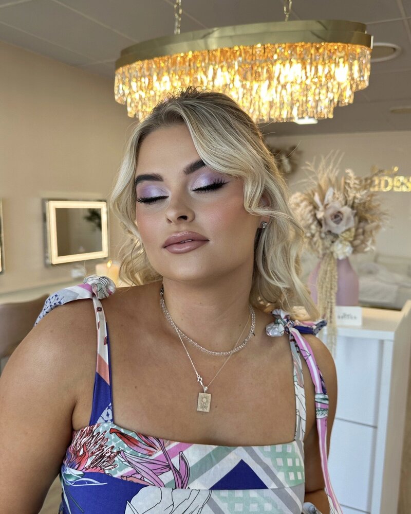 Client at our Daisy Hill, Brisbane salon with eyes closed showing her purple, shimmery eyeshadow makeup look