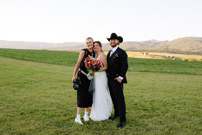 Barn wedding in Rifle, Colorado with a documentary-style photographer. Wedding couple in a field at sunset.