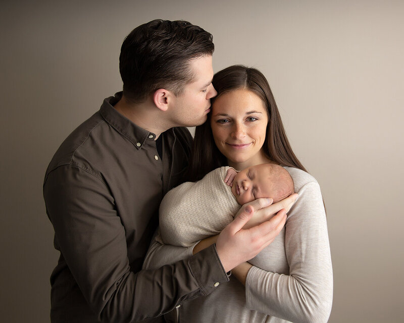 Family holding newborn son in Murrysville photo studio for newborn session.