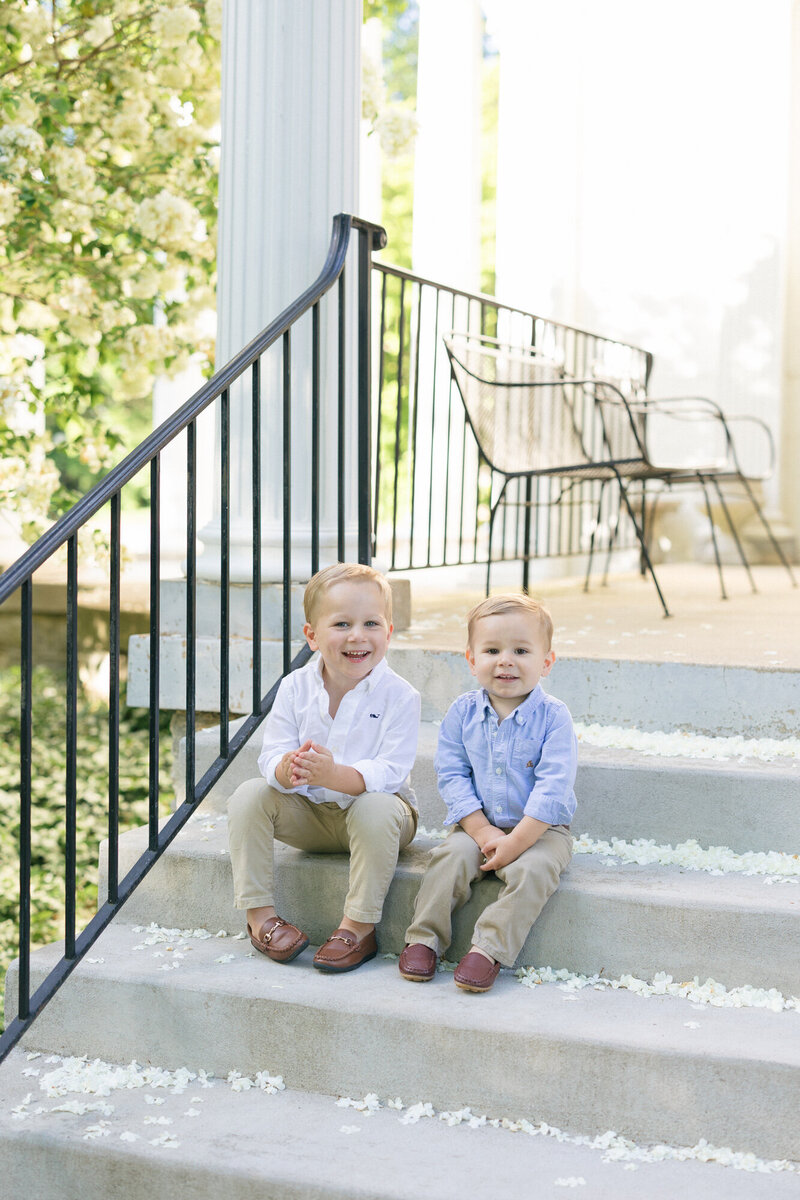 Dad holding his two sons in a green garden in louisville during their family photography session