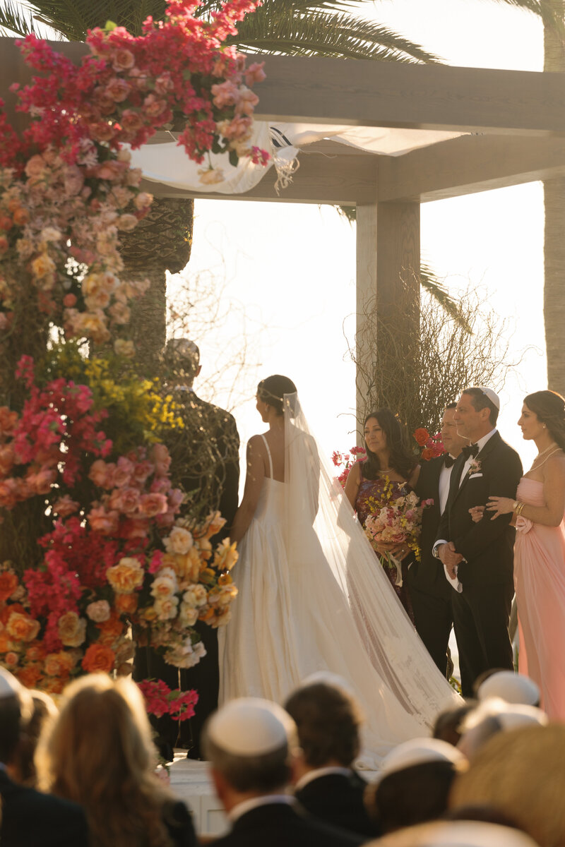 bride and groom kissing and holding bouquet during golden hour by south florida wedding photography