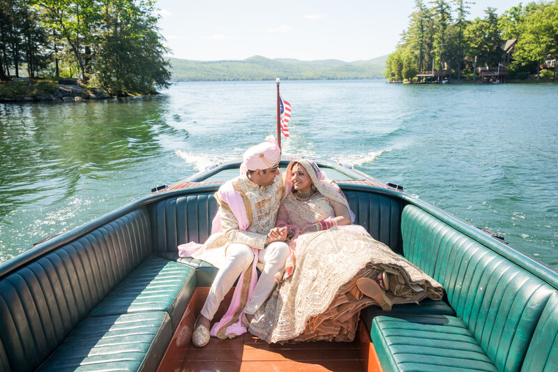 Bride and groom riding in boat in Adirondack, NY