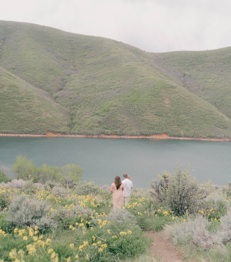 Expecting mother surrounded by nature, soft skies, and mountain peaks. PHOTOGRAPHED BY Salt Lake City maternity photographer