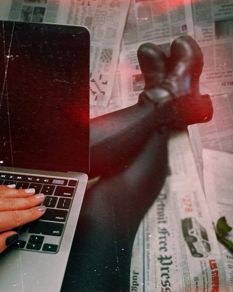 Photo of Kristina, life coach for women, sitting on the floor with legs extended and a laptop on her lap