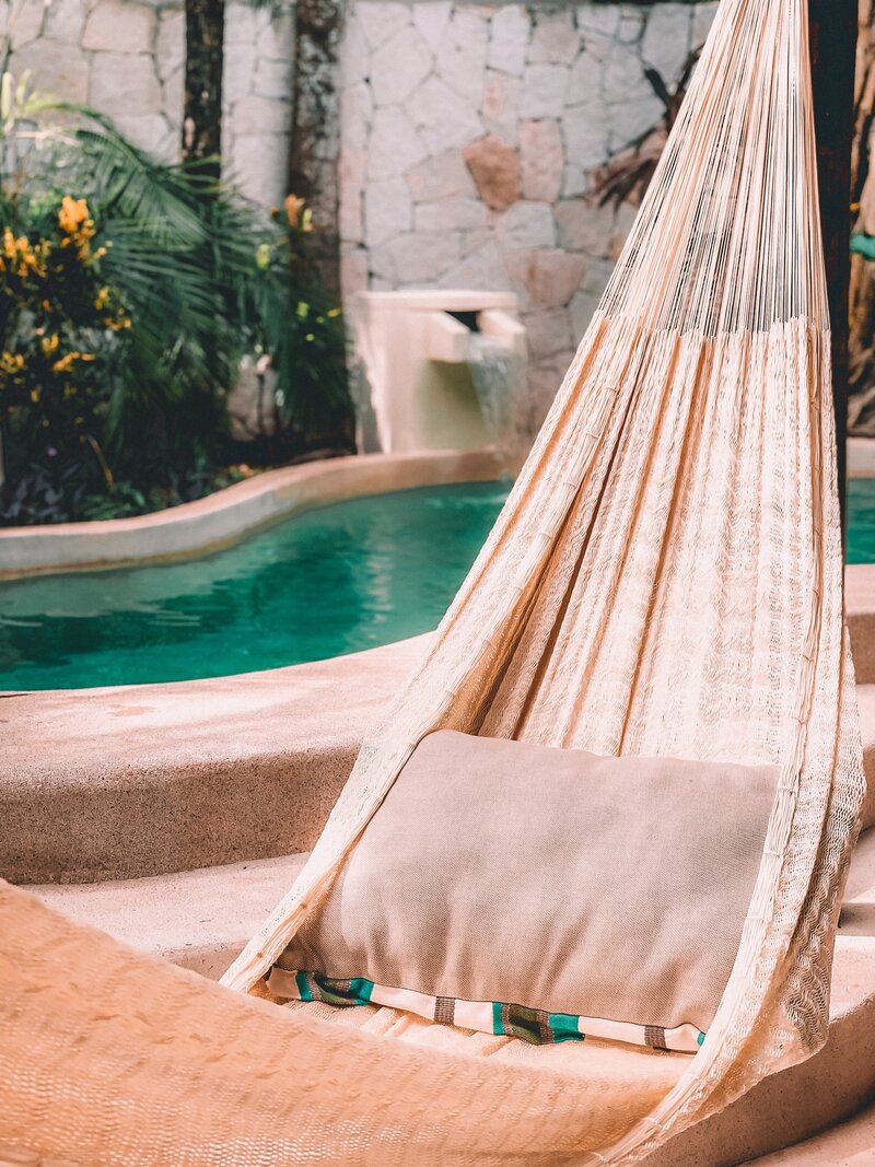 a brown hammock by a pool