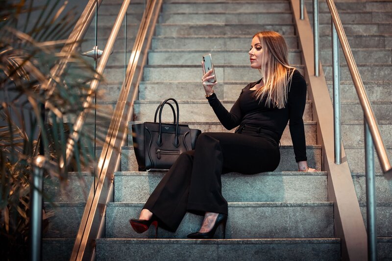 Woman sitting on a staircase looking at her phone