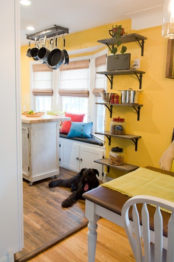wooden window seat in kitchen with bold accent pillows