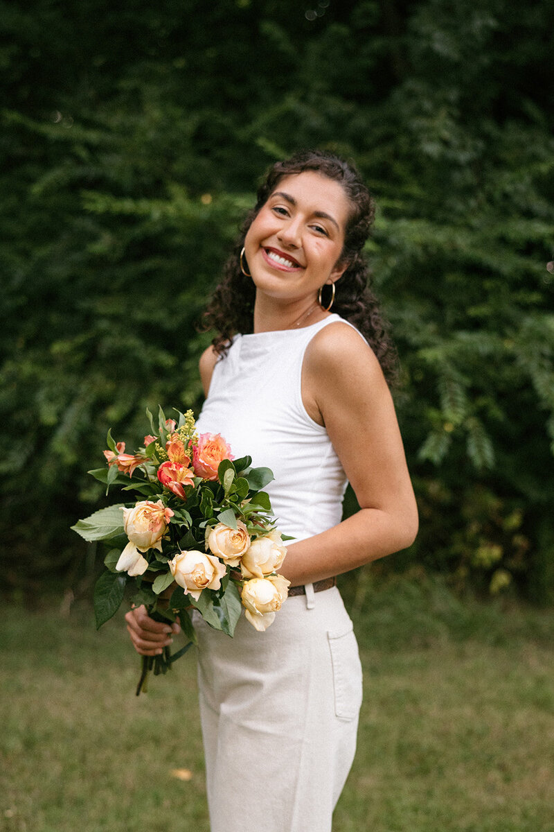 Victoria Barclay, owner of Through Victoria's Lens, holding a bouquet of flowers
