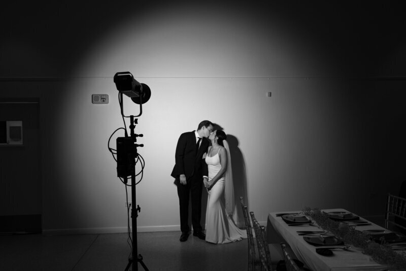 Bride and groom kissing in strobe light by wedding film photographer Noble Photo Co