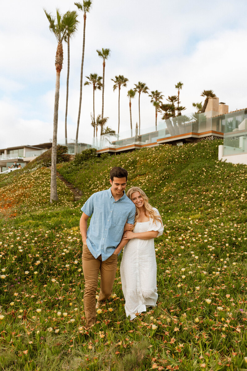 a couple walking in a field of flowers