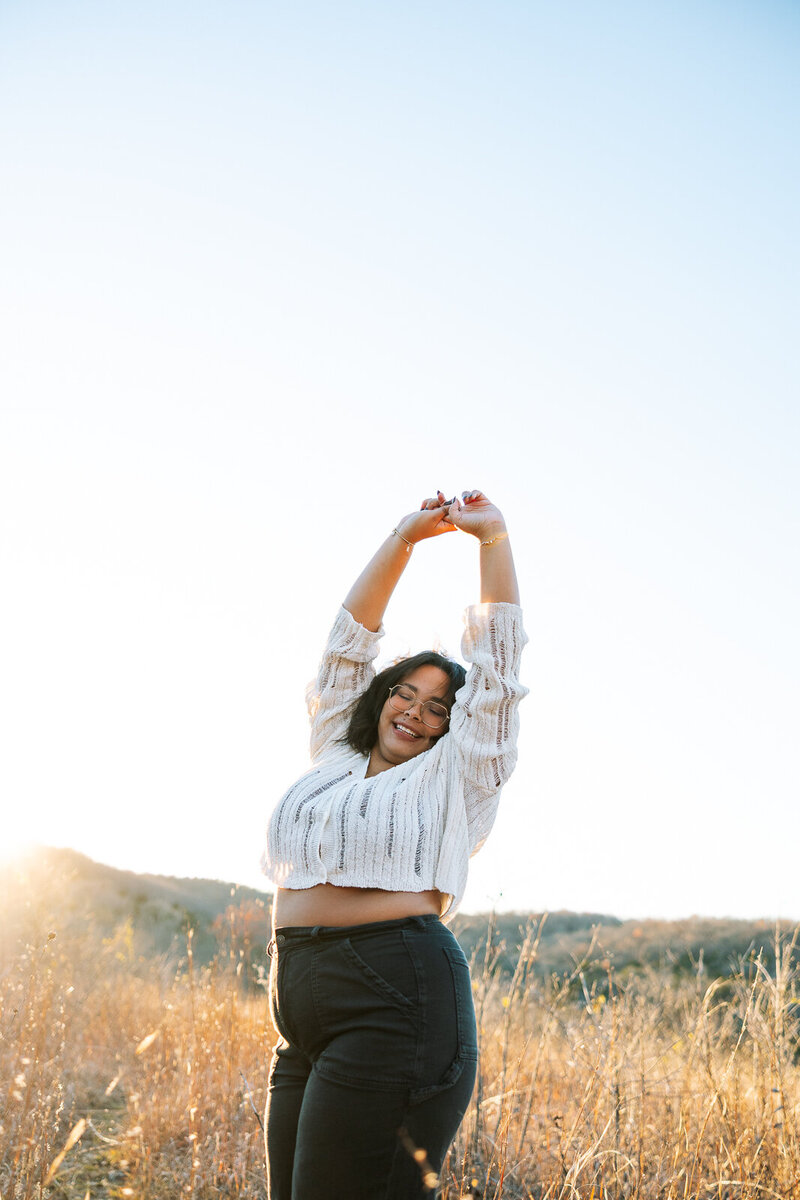 Senior girl dancing in the sun smiling. 
