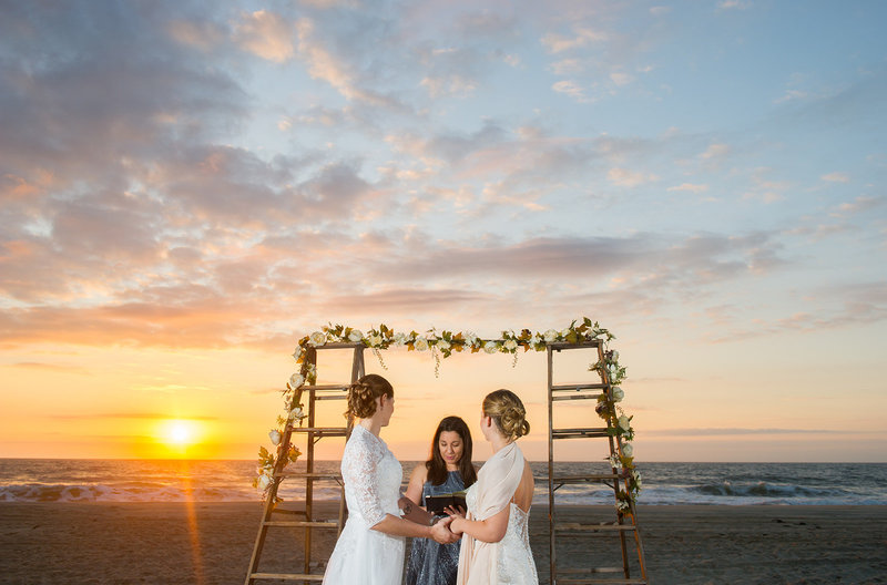 lesbian wedding at sunrise on beach