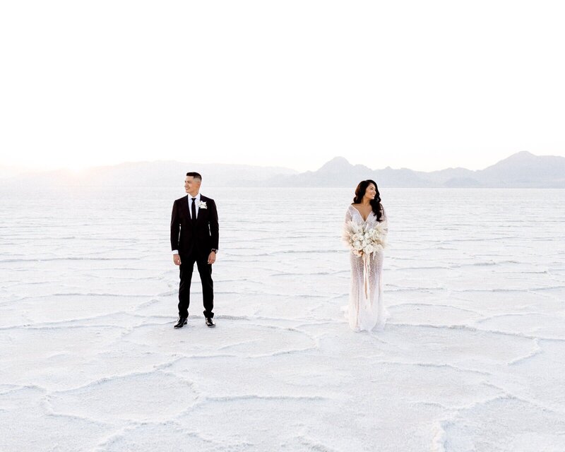 Couple just married on the salt flats during a beautiful sunset.