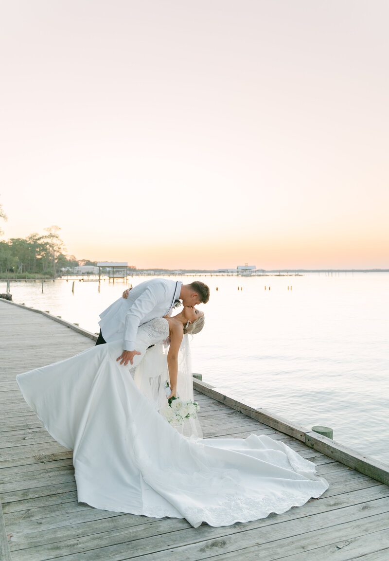 bride and groom kiss at sunset