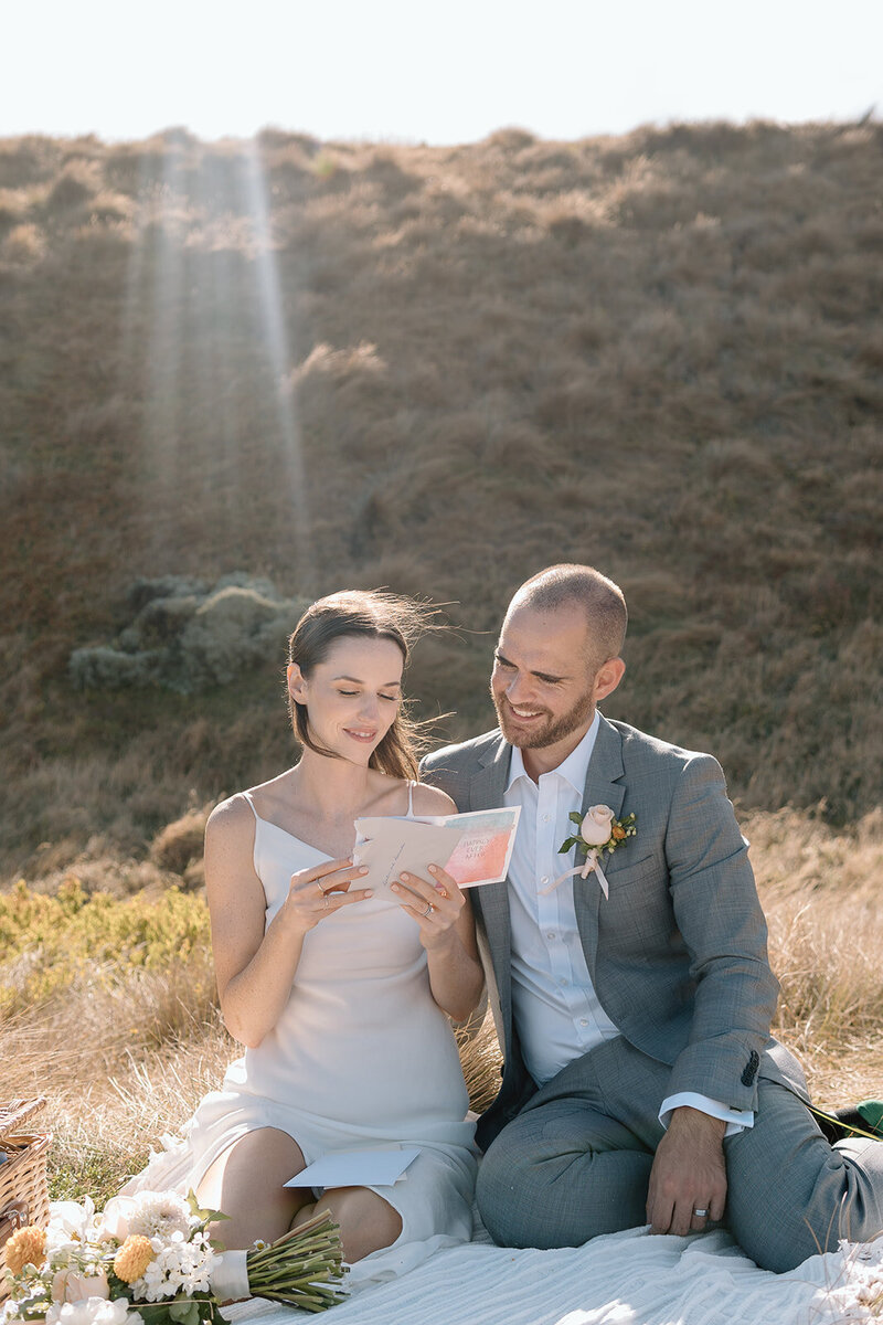 Couple reading hand written letters from loved ones on their destination elopement day
