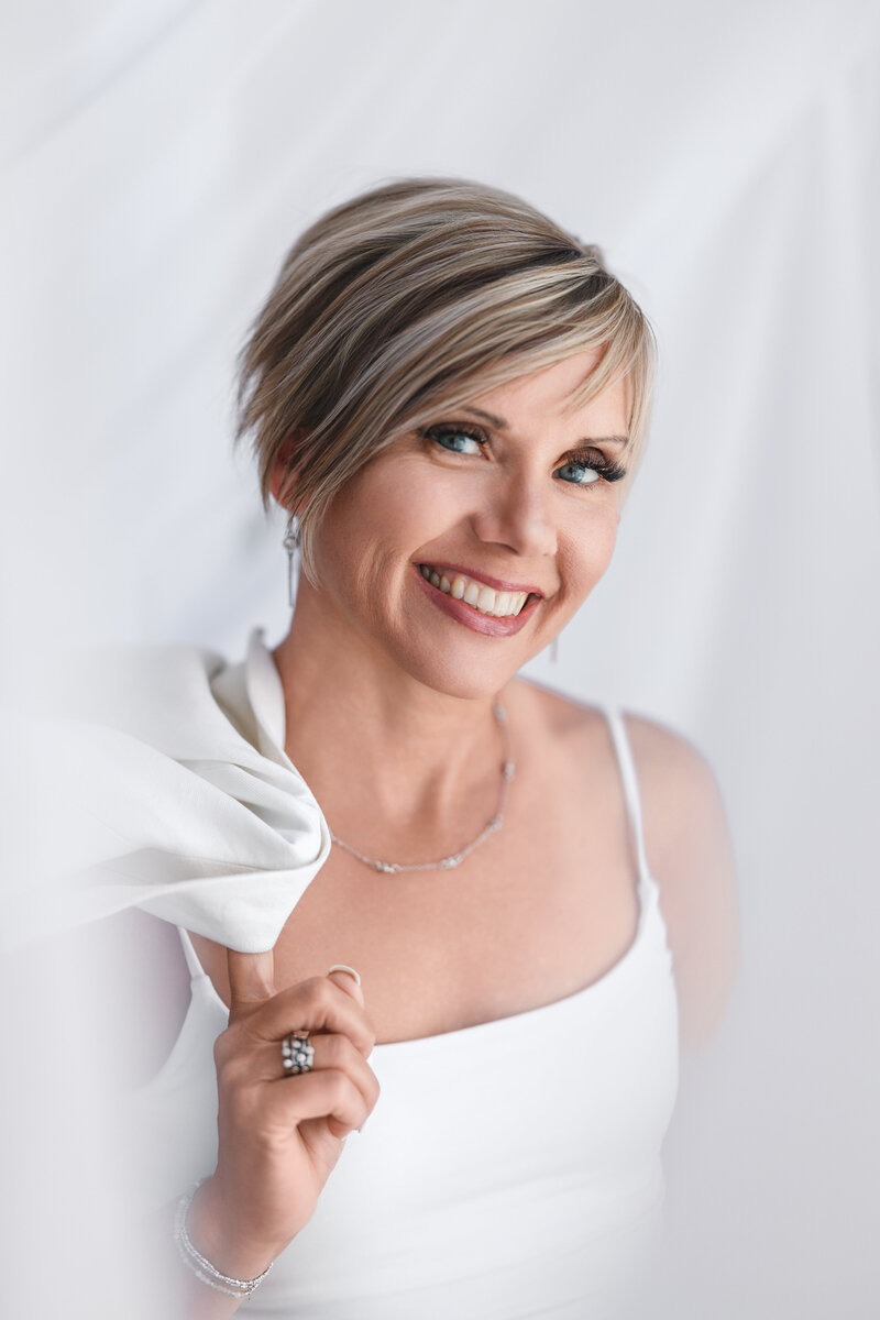 Natalie holding blue coffee mug leaning against doorway