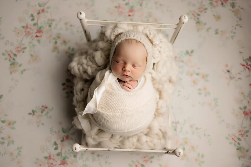 Beautiful baby girl laying in a tiny bed