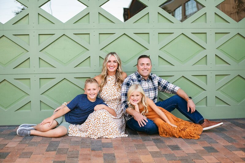 A-fashionable-family-posing-in-front-of-a-modern-green-door-in-downtown-Indianapolis-bottleworks-and-the-garage-hall-area-during-a-fun-and-candid-photo-session