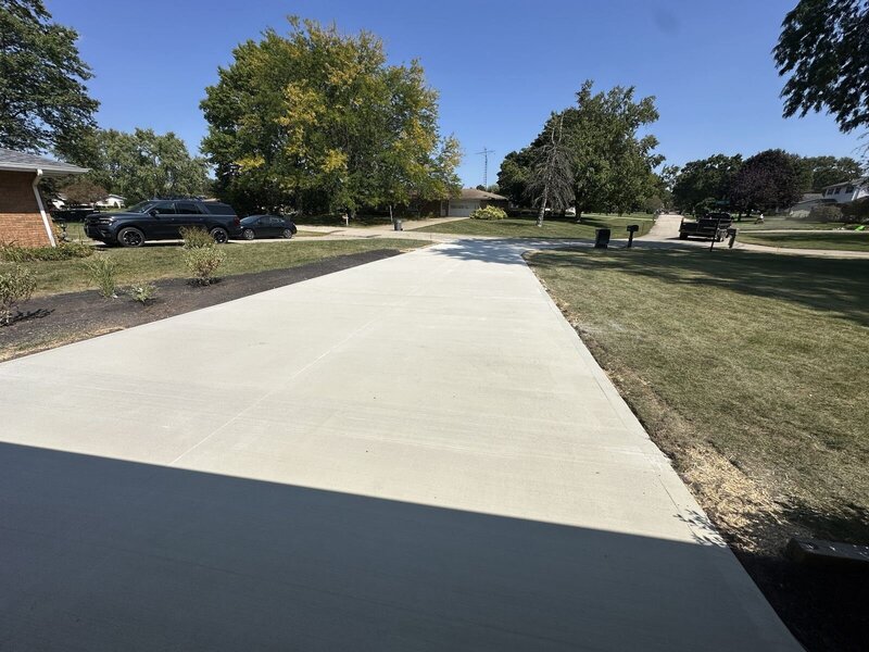 Long new concrete driveway lined with mature trees in Elkhart, IN