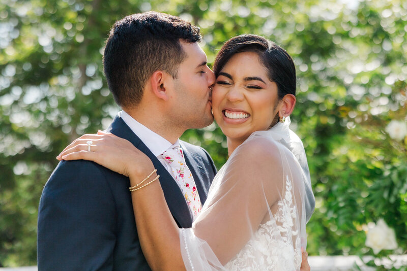Experience the joy and love of a newlywed couple sharing a tender moment on their special day. This beautiful image captures the essence of happiness and romance in a stunning outdoor setting.
