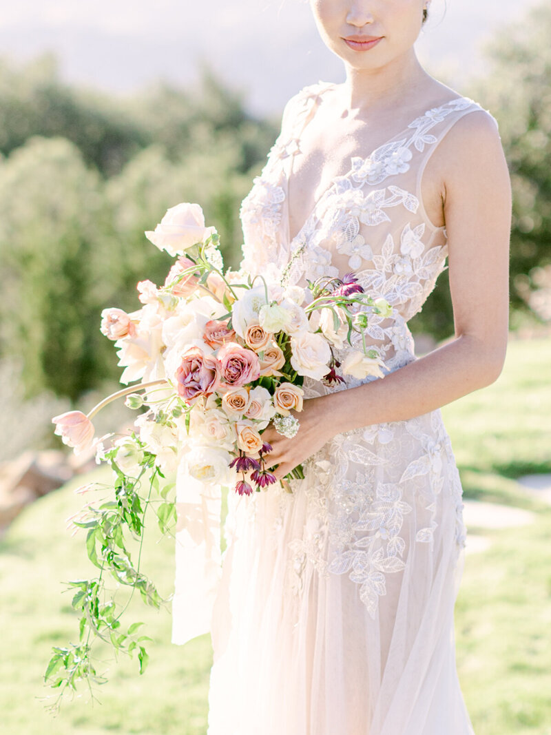 Radiant Bride Outdoors in Elegant Wedding Dress, Holding Flower Bouquet