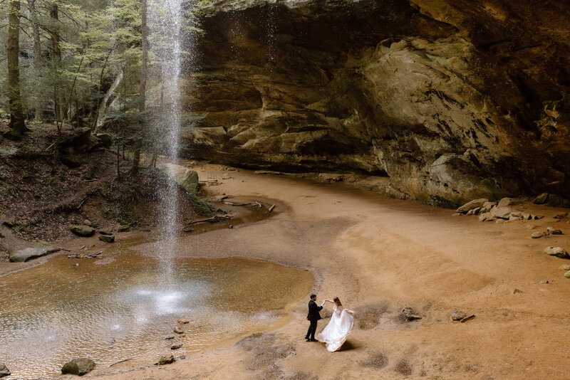 Couple dancing next to a waterfall in Hocking Hills State Park.