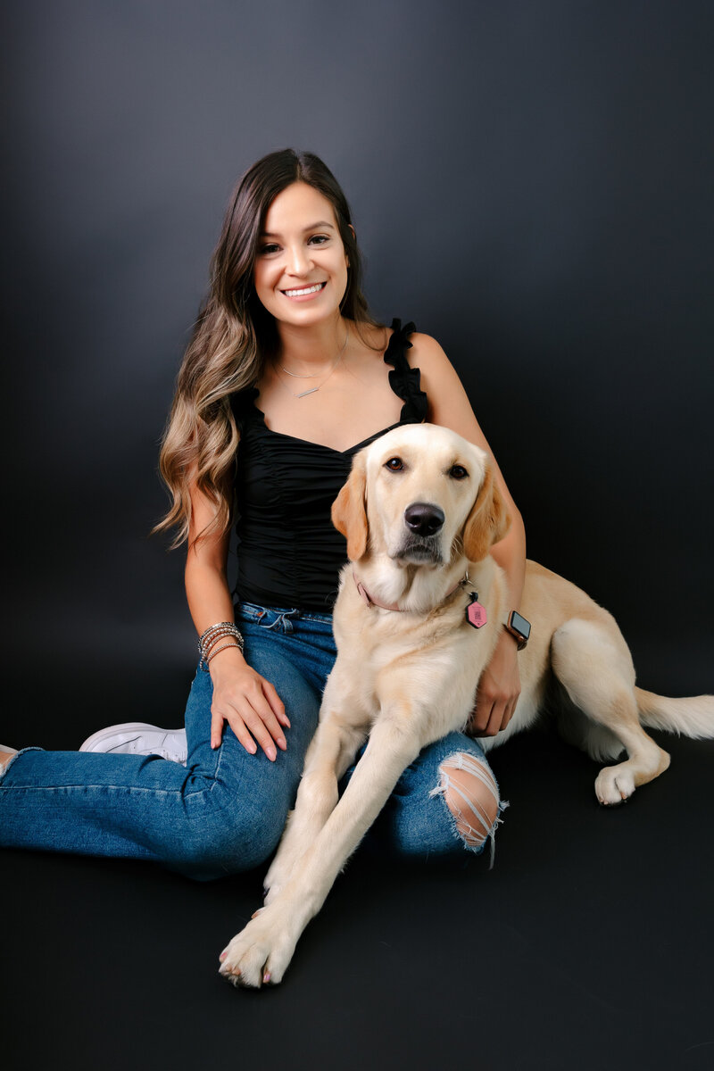 Pet owner and young golden retriever pose for photos in Sacramento pet photography studio