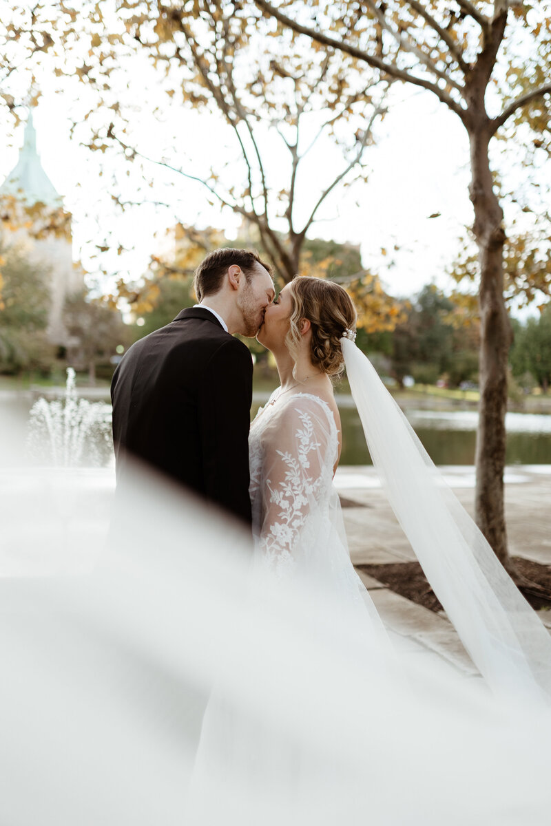A newlywed couple kisses outside of a museum in Washington, DC