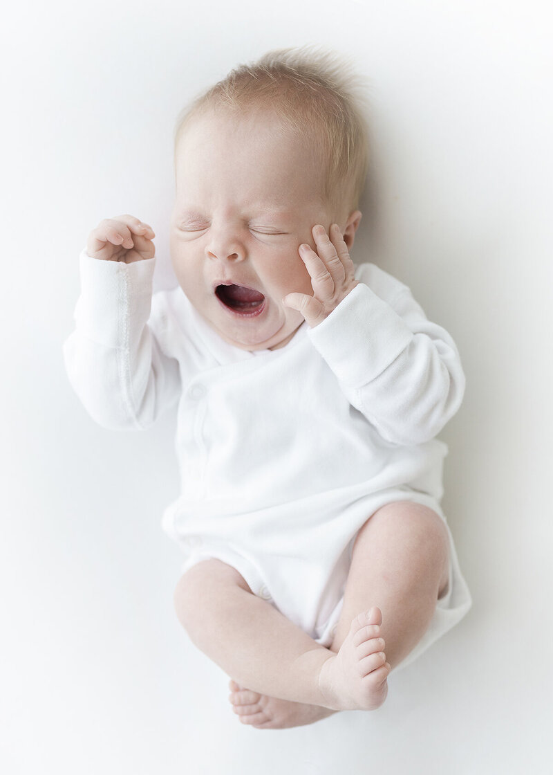 newborn baby girl photographed in a grandmillenial style in south georgia in a pink feltman brothers dress