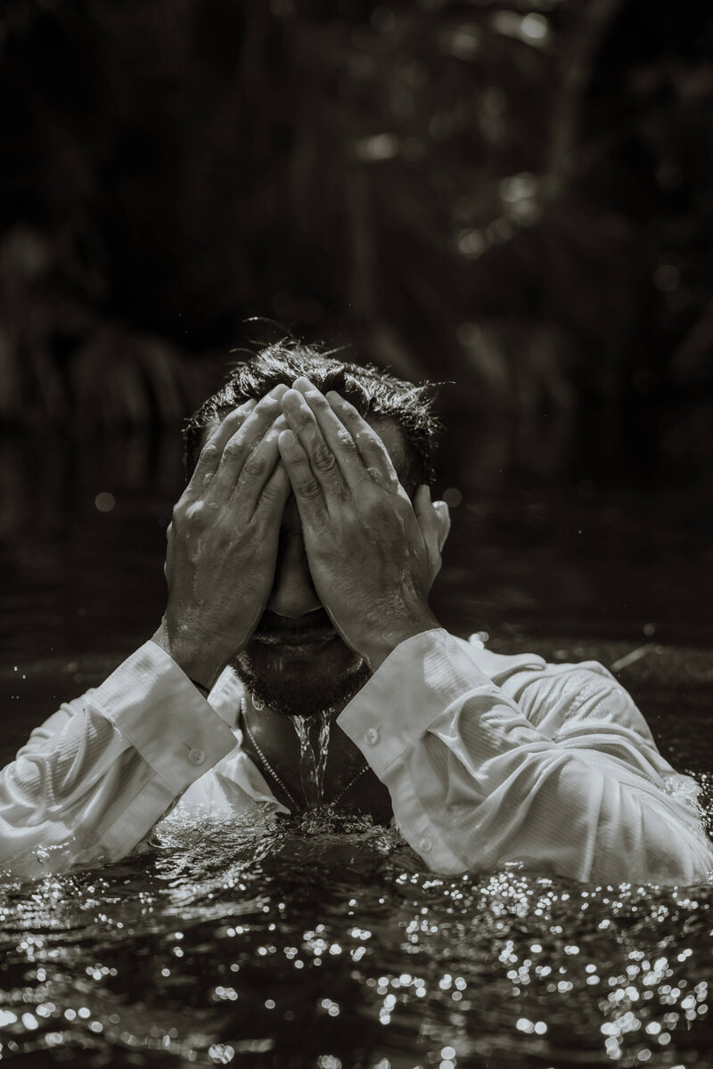 black and white photo of man coming out of water