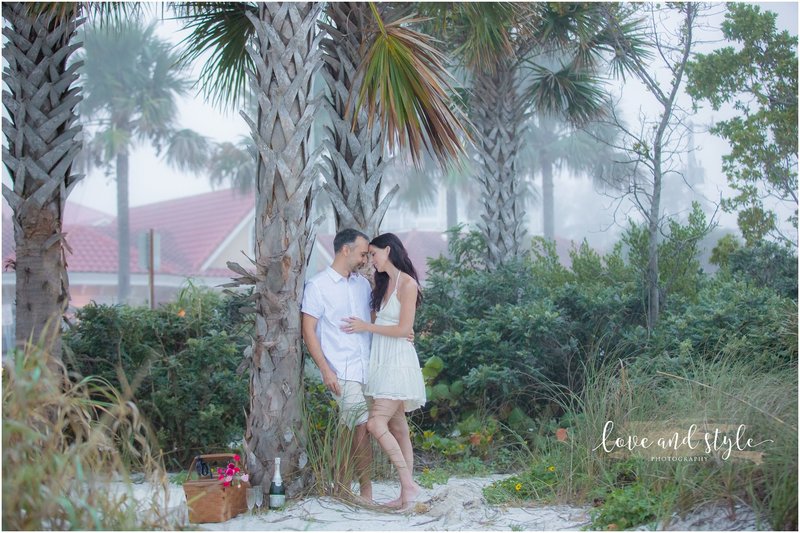 An engaged couple snuggling during a picnic on the beach on Anna Maria Island
