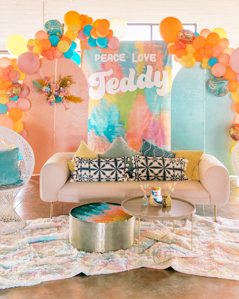 Colorful baby shower display with balloons and a couch