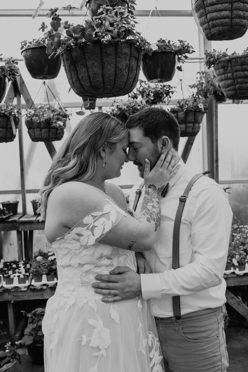 Couple Forehead to Forehead in Floral Greenhouse