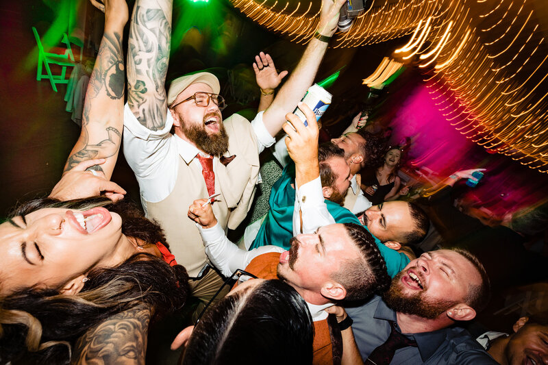 Wedding guests and the groom singing and dancing during an epic wedding recption