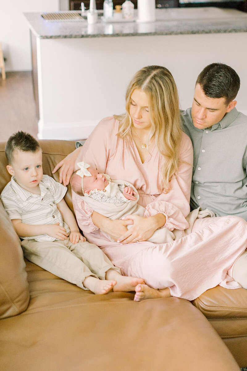 Outdoor senior portrait of a girl in a cream dress and cowboy boots walking along a wooden fence, captured by Raleigh Senior Photographer Lindsey Lambert Photography.
