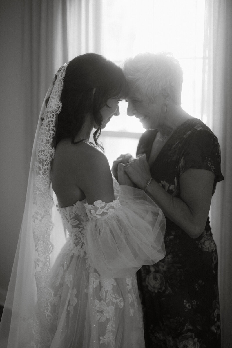 Black and white photo of a bride and groom sharing a quiet emotional moment, captured by Daniel from Rainstorm Photo & Video in a cinematic documentary style.