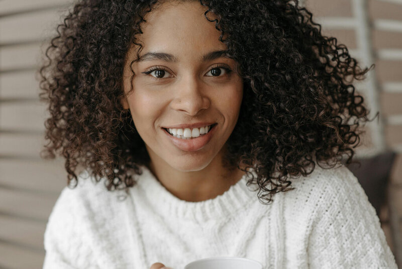 A young adult woman smiling at the camera.