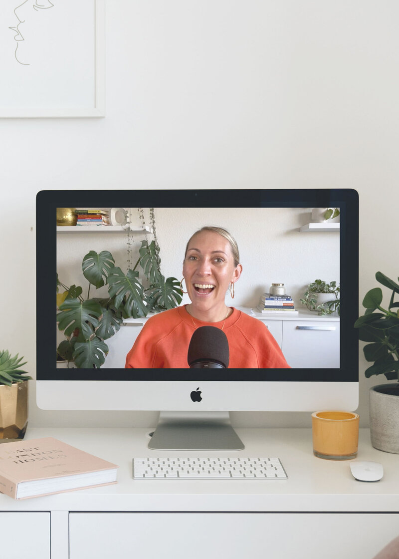 Women sitting on sofa with laptop, smiling, looking into the camera