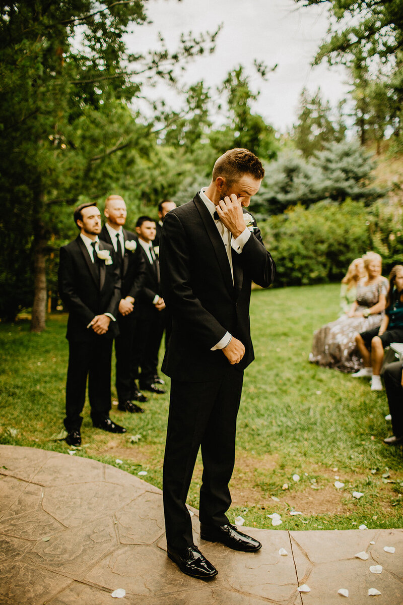 groom seeing bride in her wedding dress for the first time while standing in large open field