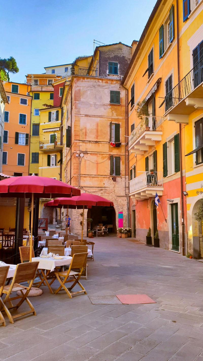 A street with umbrella, tables, and chairs